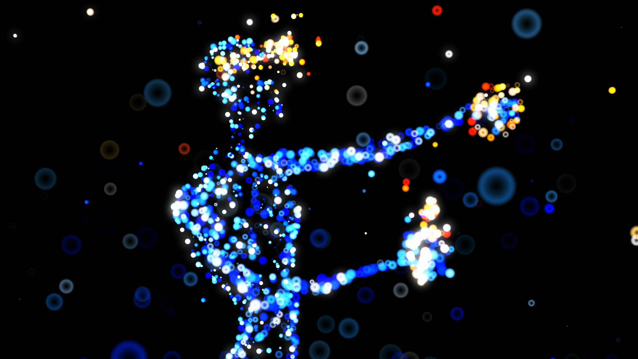 A digital, abstract image depicting a human-like figure composed of vibrant, glowing particles and bokeh light effects. The figure, predominantly in shades of blue, is reaching out with both arms, with clusters of bright yellow, orange, and red lights accentuating the hands and head. The dark background is scattered with additional soft-focus light orbs in various colors, creating a futuristic, ethereal atmosphere.